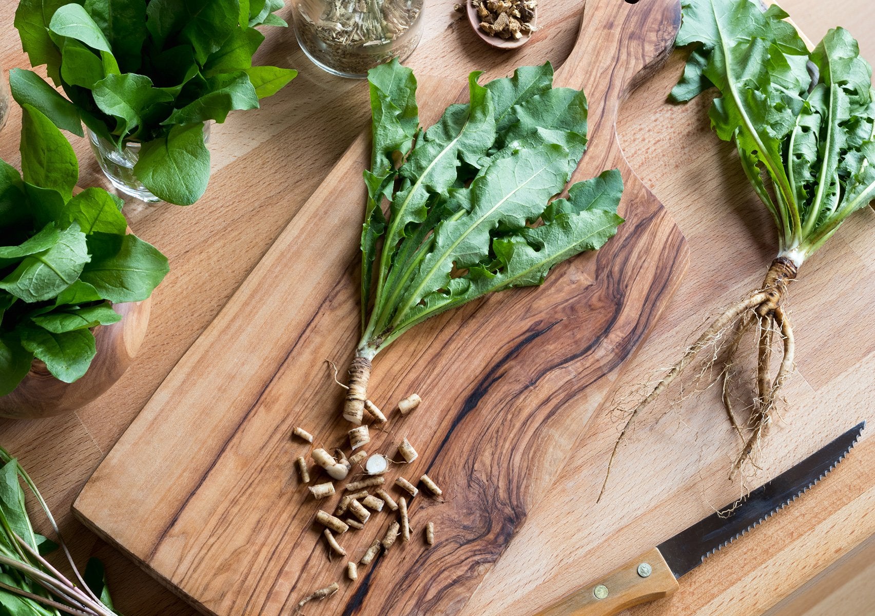 Cut-up dandelion root on a wooden cutting board on a table