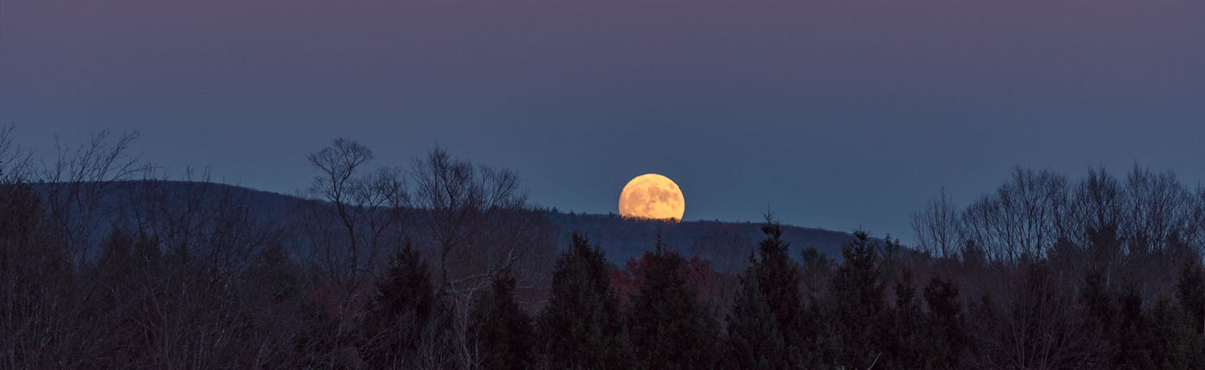 Moon peeking over mountain