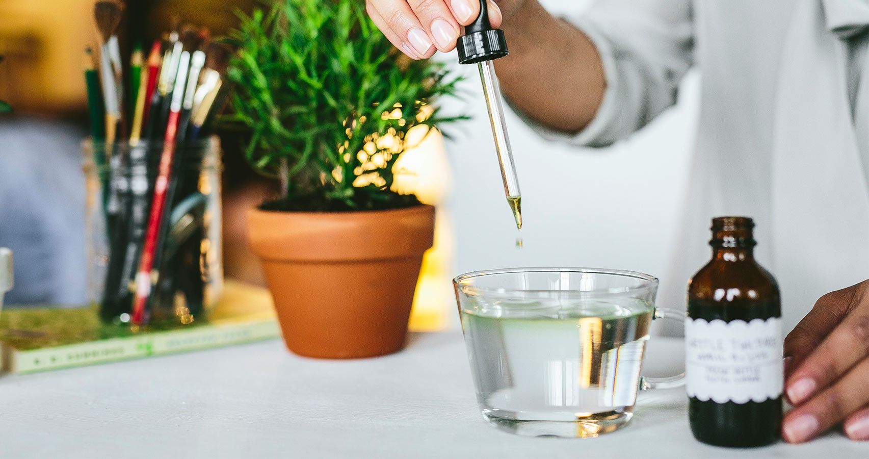 dropping nettle tincture into water glass