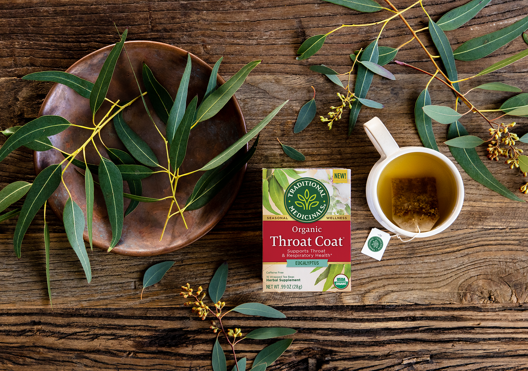 Throat Coat Eucalyptus next to fresh herbs and steeping tea